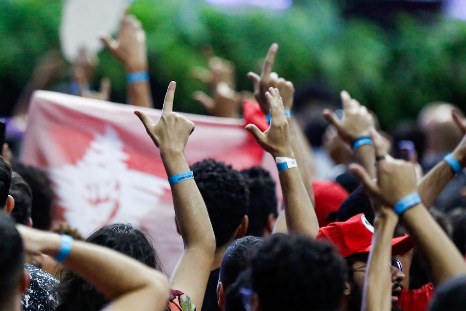 Imagem colorida mostra estudantes com as mãos levantadas fazendo o sinal de L em referência ao presidente Lula no Congresso da UNE