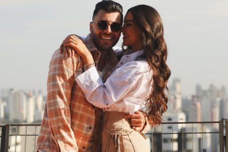 Foto colorida de Murilo Huff e Gabriela Versiani - Ele está com um óculos escuro e uma camisa xadrez. Ela está com uma camisa branca, pulseiras e aneis - Metrópoles