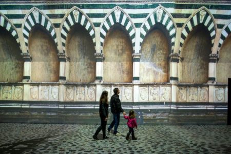 família observa projeção da cidade de florença em exposição sobre leonardo da vinci