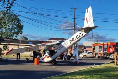 Imagem mostra avião que caiu em rua do Paraná. Na imagem é possível ver a aeronave com o bico encostado no chão e a traseira levantada. Bombeiros atendem a ocorrência - Metrópoles