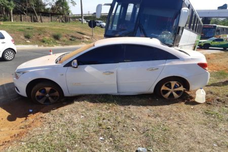 onibus de escolnha de futebol bate na lateral de um chevrolet branco, que sai da pista