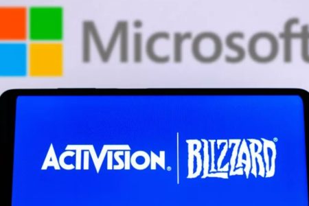 Imagem de aparelho celular com o logotipo da Activision. Ao fundo, logo da Microsoft em uma tela branca