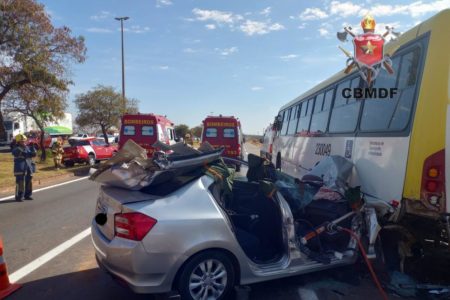 Imagem colorida de acidente em que umm carro prata bateu na traseira de ônibus amarelo