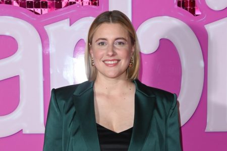 Greta Gerwig em frente a painel da Barbie - Metrópoles