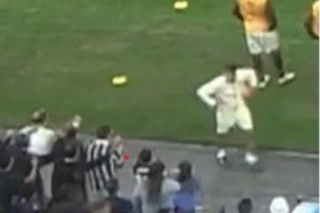 Imagem colorida de Sebastian Avellino Vargas, de branco, fazendo gestos supostamente racistas para a torcida do Corinthians