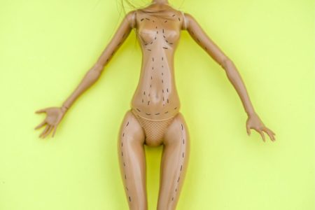 na foto, barbie sem roupa e com marcas de cirurgia plástica