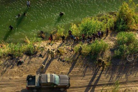 imagem colorida mostra pessoas em rio e caminhonete