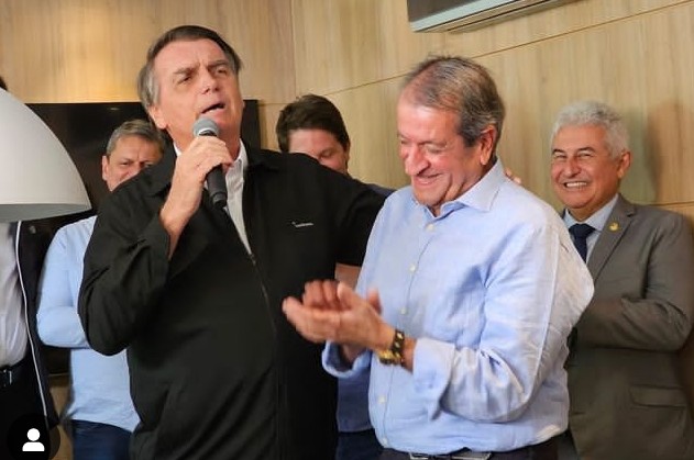 Partido Imagem colorida de Jair Bolsonaro com um microfone na mão ao lado de Valdemar Costa Neto sorrindo e aplaudindo - metrópoles