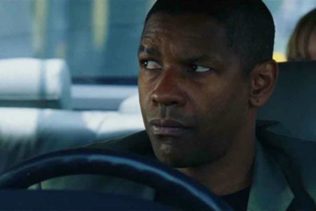 Imagem colorida de Denzel Washington dentro de um carro - Metrópoles