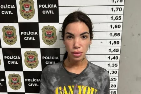 Influencer Vitória Guarizo Demito de cabelo preso em sala da Polícia Civil com marcação de altura; ela foi presa por roubar e torturar homem