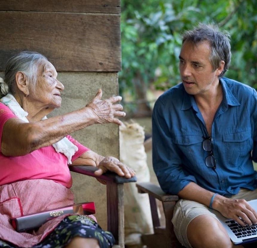 Foto colorida. A imagem mostra Dan Buettner conversando com uma idosa para sua pesquisa sobre longevidade - Metrópoles