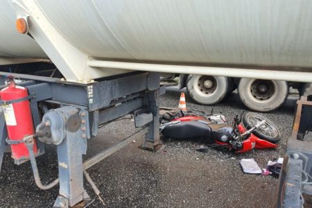 imagem colorida de moto derrubada debaixo de caminhão em acidente de João Pessoa - Metrópoles