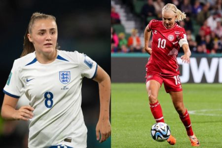 Mulher loira, vestida com uniforme branco, ao lado de jogadora loira, vestida de uniforme vermelho e com bola de futebol no pé - Metrópoles