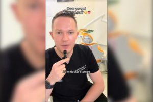 Imagem colorida de homem vestido de preto segurando microfone de lapela para gravar vídeo em consultório de dentista - Metrópoles