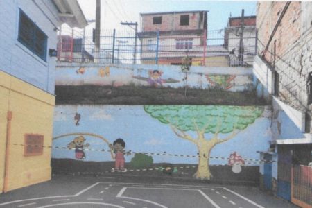 Imagem colorida mostra fita zebrada interditando terreno de escola em São Paulo. Muro ao fundo tem desenhos infantis - Metrópoles