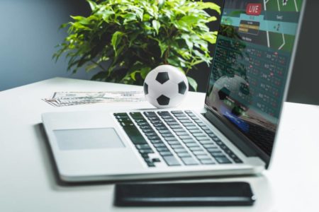 Fotografia colorida mostrando pequena bola de futebol ao lado de teclado e celular-Metrópoles