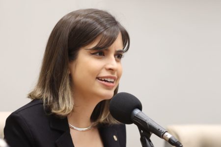 Imagem colorida de Tabata Amaral, mulher branca de cabelo liso preto na altura do pescoço, vestindo terno preto e falando ao microfone - Metrópoles