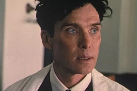 Foto colorida de Cillian Murphy. Na imagem, ele aparece com um terno preto e jaleco branco. Ele está caracterizado para o filme Oppenheimer - Metrópoles