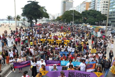 Foto mostra multidão de mulheres com faixas ocupando Copacabana