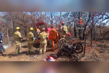 Imagem colorida de um acidente envolvendo um carro vermelho r uma moto na DF-180. Bombeiros atuam no local- Metrópoles