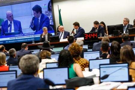 imagem colorida mostra sessão da cpi do mst com deputados sentados em frente a computadores e deputado ricardo salles com microfone na mão