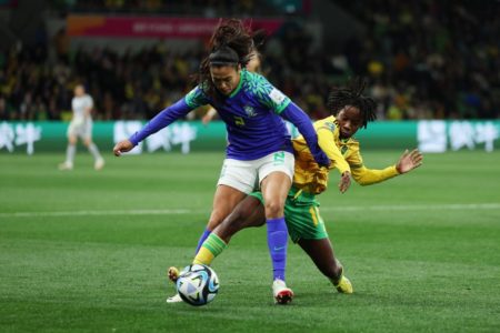 Imagem colorida da jogadora jamaicana tirando bola de brasileira - Metrópoles