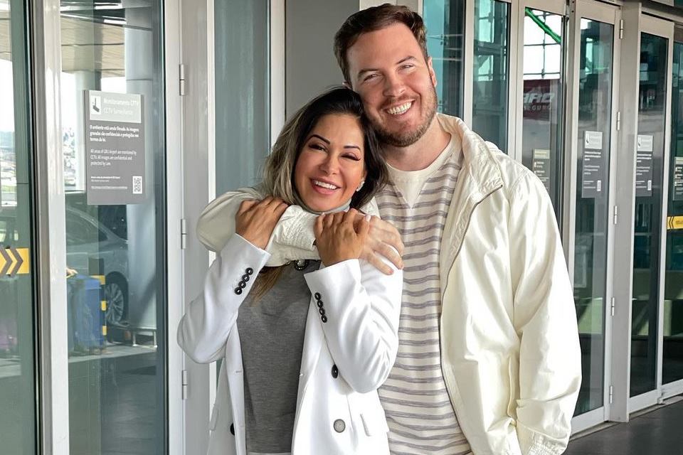 Foto colorida de Maíra Cardi e Thiago Nigro. Eles estão sorrindo, abraçados e de roupas claras - Metrópoles