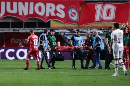 Imagem colorida do jogador sendo atendido pela equipe médica em campo - Metrópoles