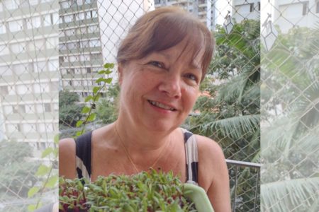 Mulher segura planta em varanda de apartamento - Metrópoles