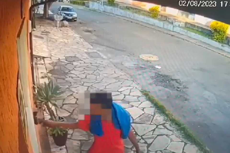 homem com camisa vermelha tocando campainha de casa