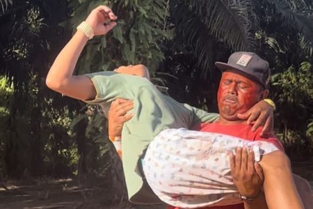 Imagem colorida mostra indígena sendo carregado por homem após ser baleado - Metrópoles