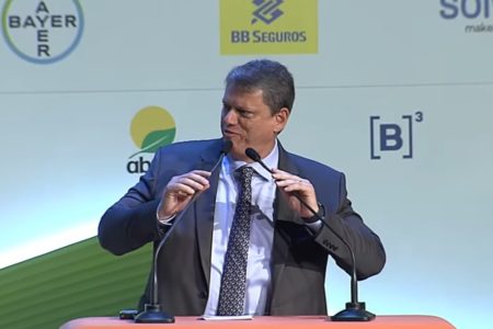 Imagem colorida de Tarcísio de Freitas, governador de São Paulo, falando em um microfone durante evento do agronegócio. Ele veste um terno escuro e usa gravata - Metrópoles