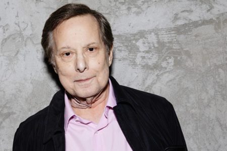 Foto colorida de William Friedkin de camisa rosa e terno - Metrópoles