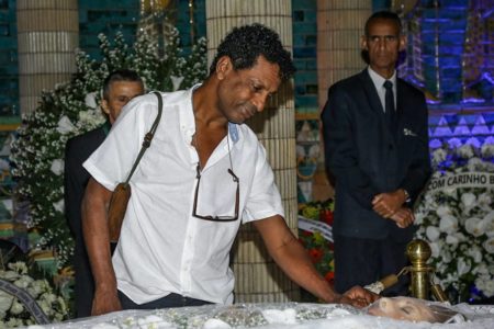 Foto colorida de Luis Mirando no velório de Aracy Balabanian, ao lado do corpo e do caixão da atriz - Metrópoles