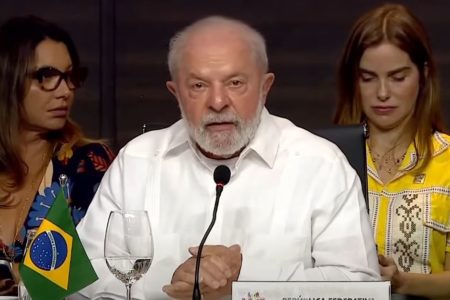 Imagem colorida mostra Lula de camisa branca em discurso