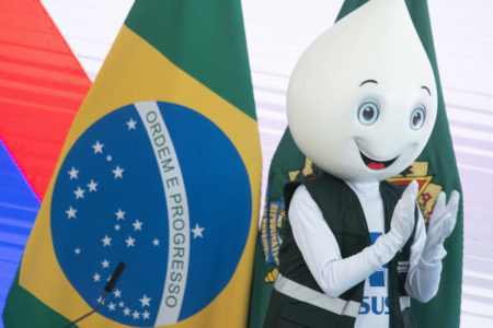 imagem colorida mostra mascote zé gotinha usando colete do sistema único de saúde (SUS) e batendo palma