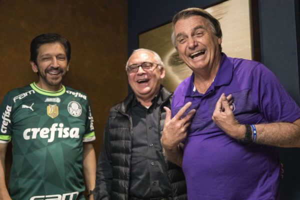 ricardo nunes de camisa do palmeiras e bolsonaro de camisa roxa. já um homem entre eles, de preto