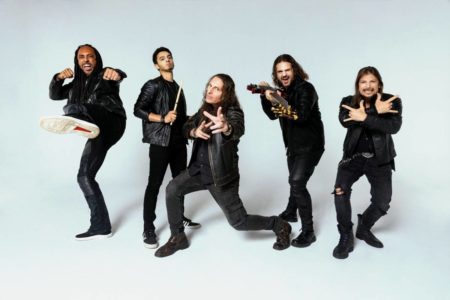 foto de cinco homens em poses variadas vestidos de roupas pretas e jaquetas de couro - metrópoles