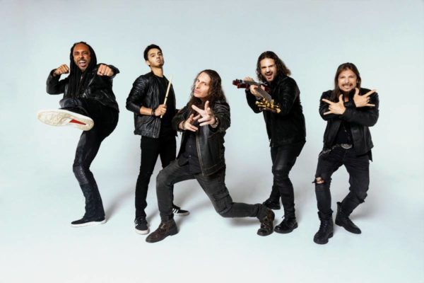 foto de cinco homens em poses variadas vestidos de roupas pretas e jaquetas de couro - metrópoles