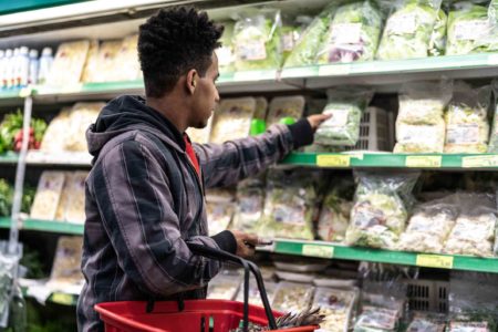 Foto mostra homem escolhendo salada pré-pronta em mercado