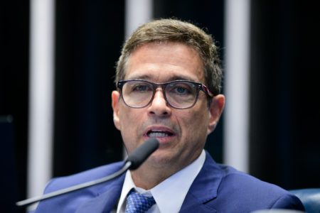 Imagem do rosto de Roberto Campos Neto, presidente do Banco Central. Ele fala ao microfone do Senado e usa óculos - Metrópoles