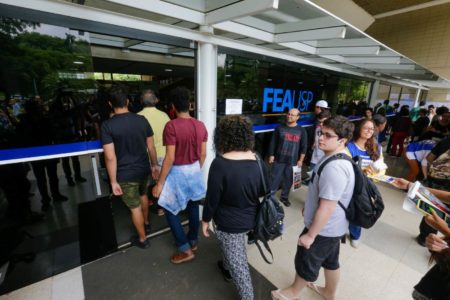 Foto colorida: alunos entram no prédio da FEA-USP para prestar o vestibular Fuvest