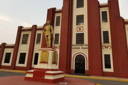 imagem colorida mostra prédio nas cores creme e vermelho com estátua dourada na frente, onde funciona o colégio militar leoncio prado no Peru - Metrópoles