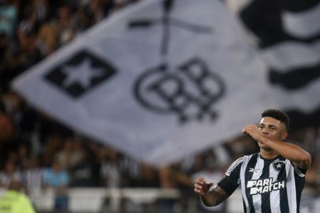 Foto de jogador do Botafogo Luis Henrique comemorando gol com torcida ao fundo