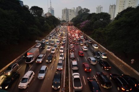 Imagem colorida mostra a 23 de Maio, avenida larga e repleta de carros em São Paulo, com a cidade ao fundo - Metrópoles