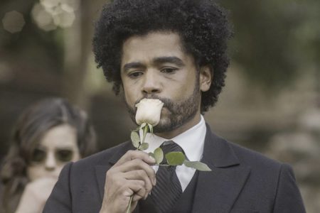 Foto colorida de Orlando beijando uma rosa branca - Metrópoles