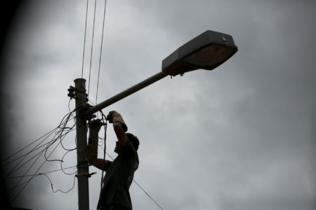 Ligação clandestina na rede de energia eletrica. Homem faz gato na rede de energia elétrica