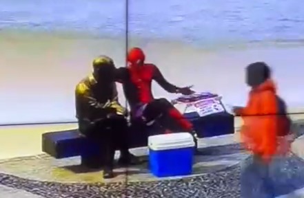 imagem colorida de homem fantasiado de homem-aranha ao lado de estatua de carlos drummond de andrade - Metrópoles