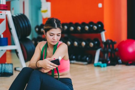 Foto mostra mulher diabética sentada em academia avaliando os n[iveis de insulina em seu sensor - Metrópoles