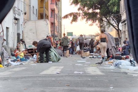 Imagem pessoas caminhando em meio à rua suja na região da Cracolândia, no centro de São Paulo - Metrópoles